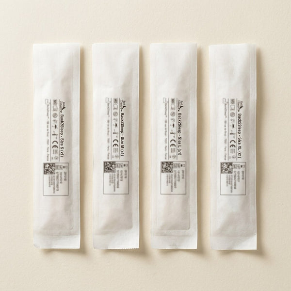 Four sealed Back2Sleep sachets in sizes S, M, L, XL on cream paper