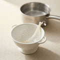 Lifting the Back2Sleep silicone nasal stent out of hot water with a strainer to store it
