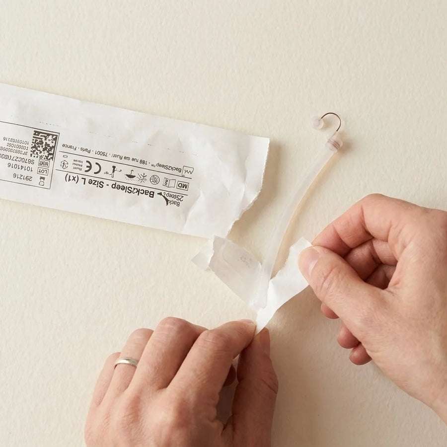 Hands opening the Back2Sleep nasal stent sachet from the kit